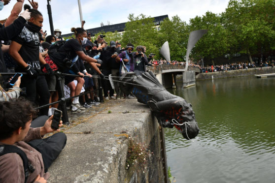 Protesters throw a statue of Edward Colston into Bristol harbour during a Black Lives Matter protest rally,