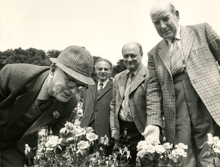 Mr James Bruce smelling the roses in the Duthie Park with David Welch, Patrick Linton and James Riddell.
