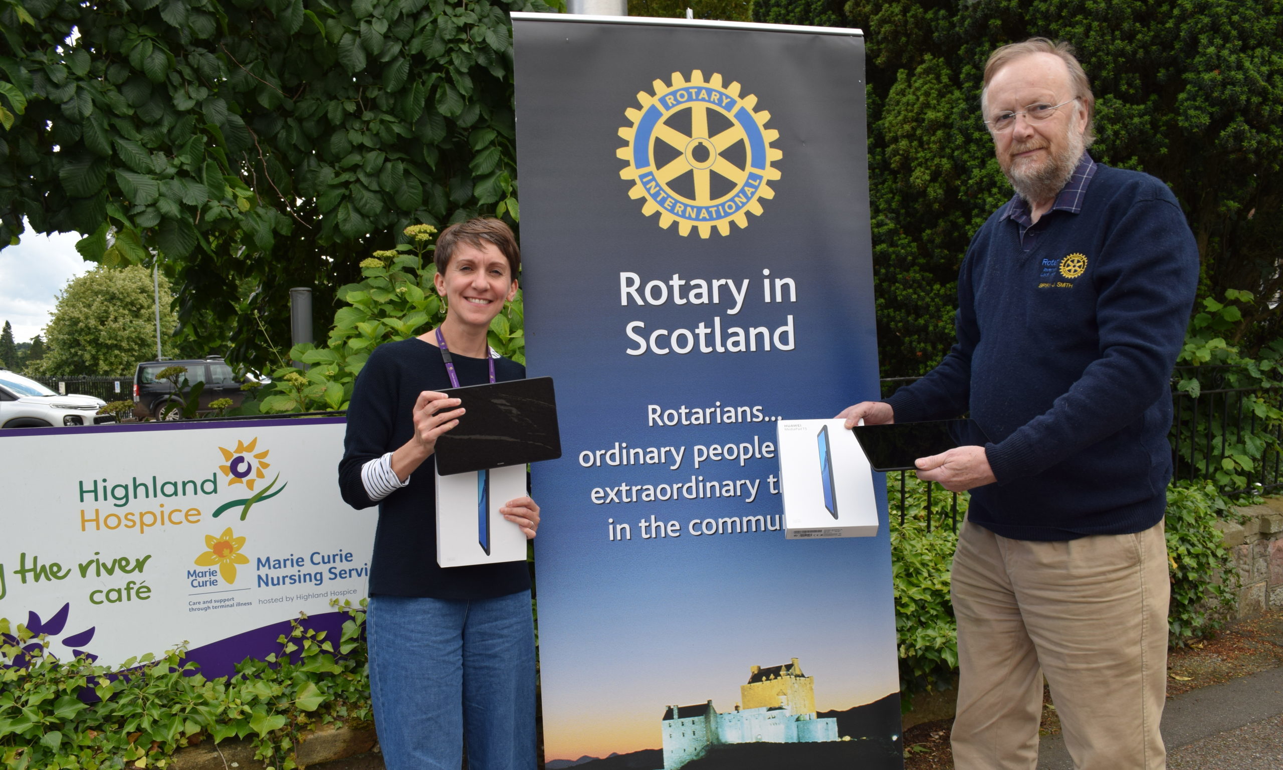 Jennie Devlin, of Highland Hospice, receiving the tablets from president of RCILN Bryan Smith