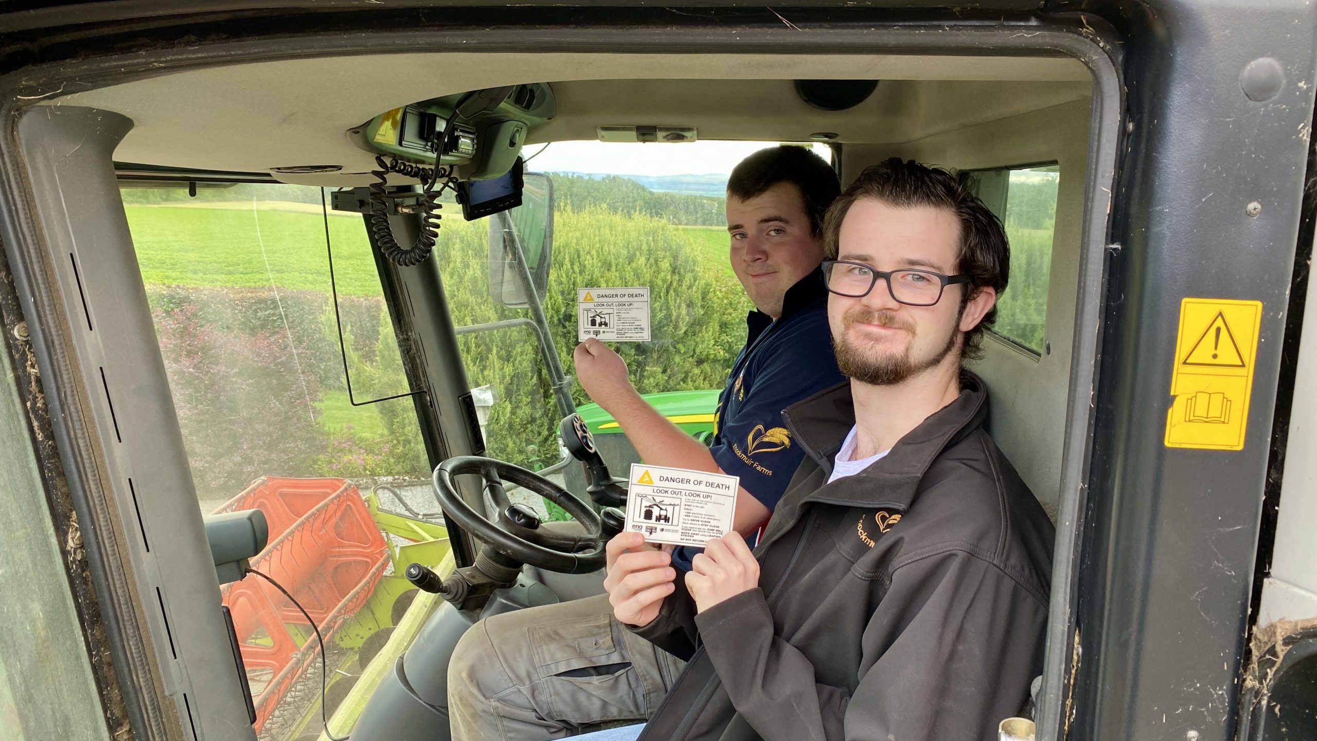 Ewan (in blue) and Ross MacIver with the SSEN farm safety stickers.