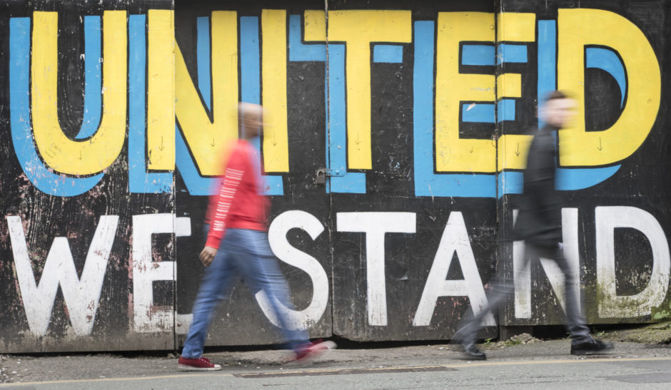 A general view of people walking past graffiti in Leeds.