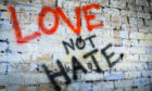 Graffiti on a wall which says love not hate.