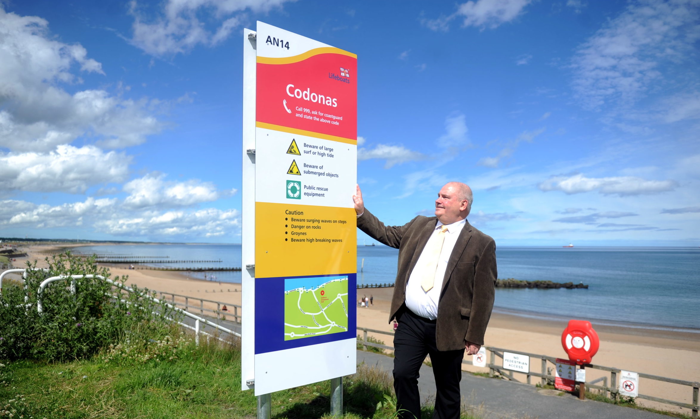 Councillor Dell Henricksen with one of the new safety signs at Aberdeen beach.
