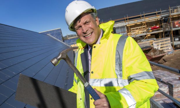 Ron Taylor fits the last slate to the roof of Parklands new Care Home at Fortrose