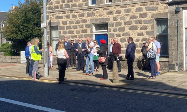 Aberdeen City Councils chief officer for capital projects, John Wilson (centre, in white) discusses the concerns of Rosemount residents and traders.