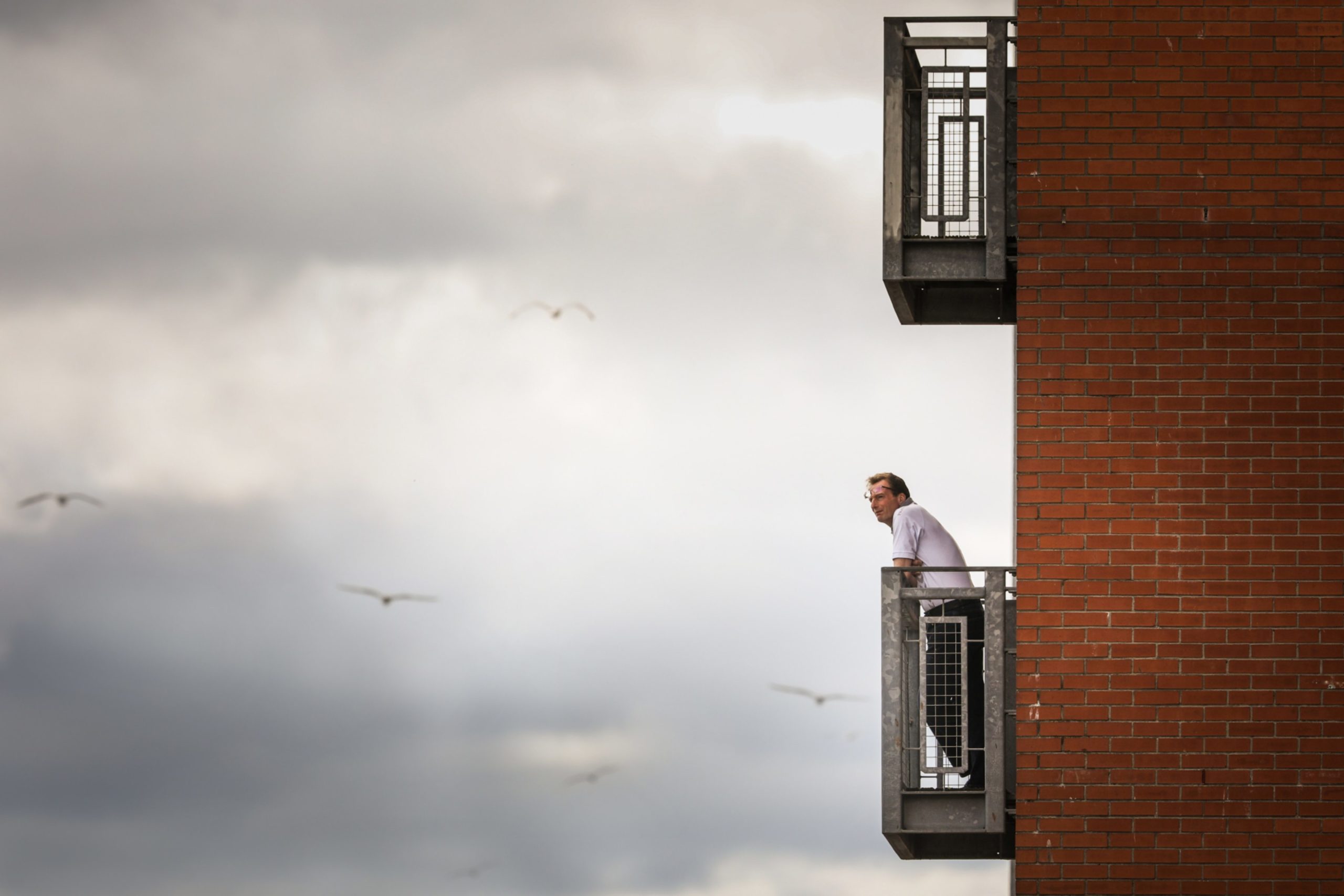 A man stands on his balcony at the City Quay, Dundee, to get some fresh air. Picture by Mhairi Edwards