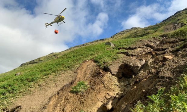 The helicopter bringing water bags to site to help move large 100 tonne boulder to safety