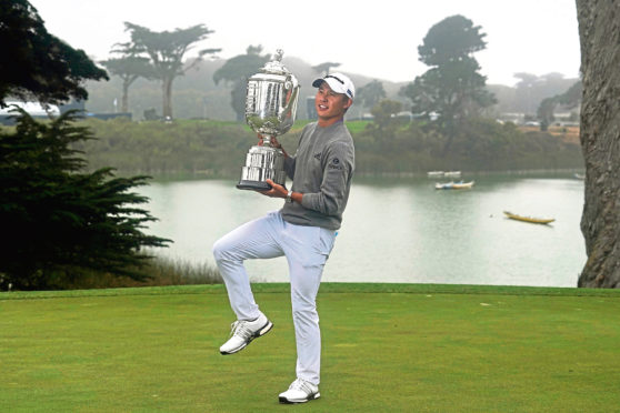 Collin Morikawa holds the Wanamaker Trophy