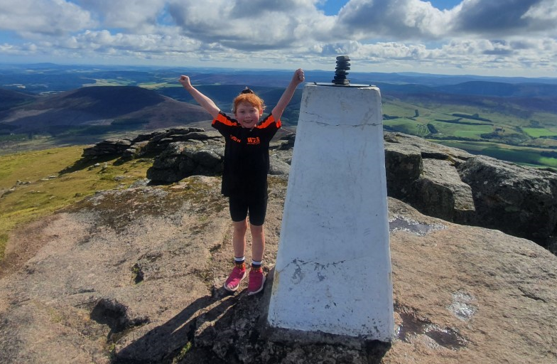 Joy as Evelyn Mitchell reaches the top of the Ben Rinnes in fundraiser.