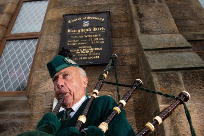 Beadle Piper Patrick Glendinning pipes outside Burghead's Church of Scotland in tribute to Christopher Stuchbury.
Pictures by JASON HEDGES