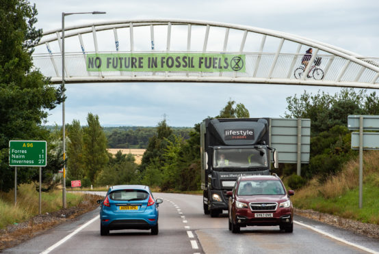 Extinction Rebellion campaigners unfurling banners calling for the end of fossil fuels.