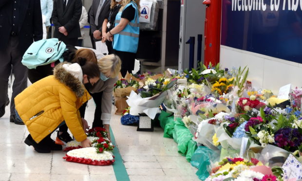 Family members laying wreaths and floral tributes at Aberdeen station. 

Picture by Kenny Elrick