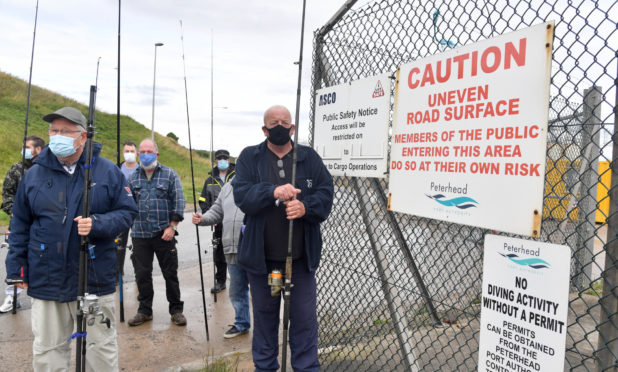 Members of Peterhead and District Angling Club stage a peaceful protest at weekend. They have been dismayed by the decision to prevent them fishing from the breakwaters on safety grounds.