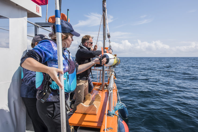 The team at Woods Hole Oceanographic Institution (WHOI), prepare to deploy their underwater robot camera, to follow a tagged basking shark.