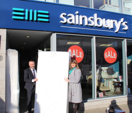 Michelle Flecher-Herd from AberNecessities and Philip Sainsbury from Sainbury's Furniture Store promote the charity's children's bed appeal.