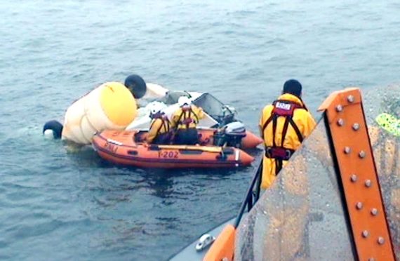 RNLI and coastguard volunteers inspecting the wreckage