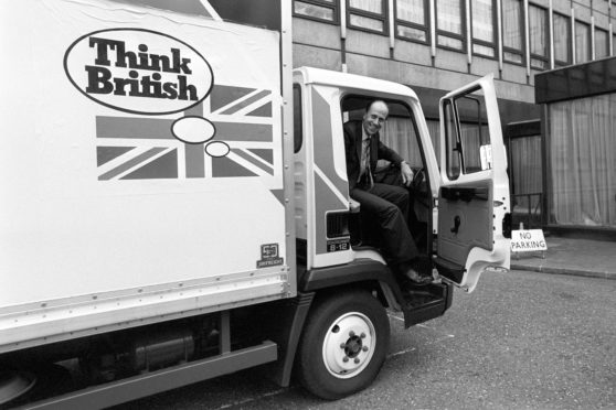 Norman Tebbit ready to step from the Leyland Roadrunner after parking it following his 'test' drive in London when it was launched.