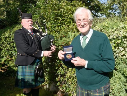 Picture by SANDY McCOOK  17th September '20
CR0023848   John Kay, of Ashton Road, Inverness and formerly of the Royal Scots with his medal from the Royal British Legion with which he was presented yesterday. Also in the photograph is piper Tam Cornwall, also formerly of the regiment.