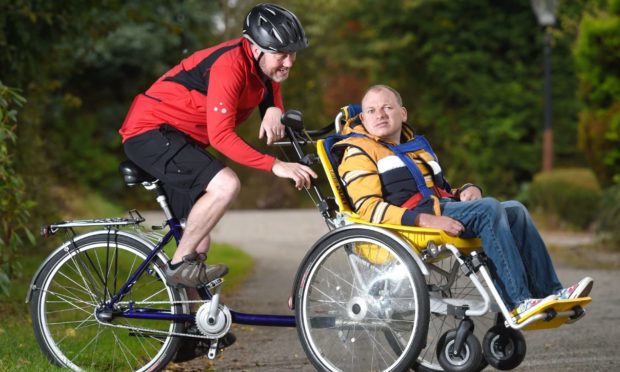 James Murray of Kirkhill on his wheelchair bike with brother in law Mark Forbes at the pedals.
