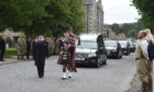 After a private family funeral, the cortege, led by a piper, made its way down the main street in Tomintoul to the local cemetery.