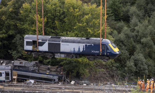 A carriage is lifted by crane from the site of the Stonehaven rail crash
