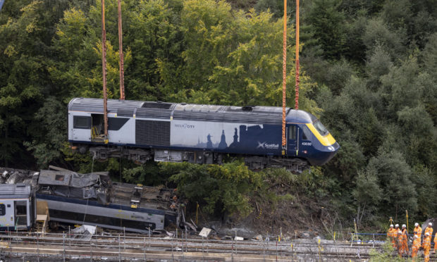 A carriage is lifted by crane from the site of the Stonehaven rail crash.