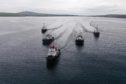 The two new tugs arrive in Scapa Flow, escorted by the three currently in service