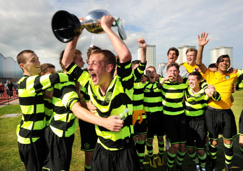 Celtic captain John Herron holds up the cup with his team behind him after winning the final AIFF