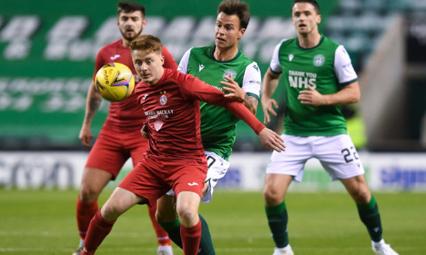 Brora’s Andy Macrae battles for possession against Hibs.