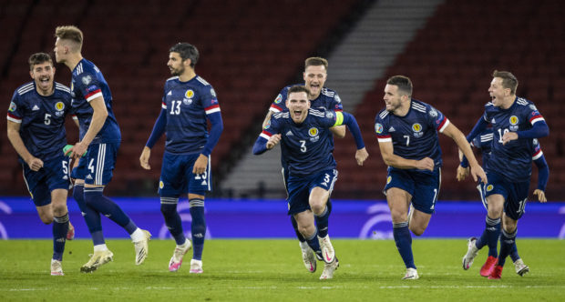 Scotland players run for Kenny McLean after he nets the decisive spot-kick.