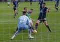 Ross County goalkeeper Ross Doohan, left, makes a big save to deny Hibs' Christian Doidge in the Premiership last month.