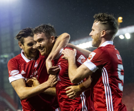 Ash Taylor and Marley Watkins celebrate with Tommie Hoban after the latter's goal against Hamilton.