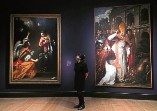 Actor Ellice Stevens poses next to the works (left) Annunciation and Saint Januarius by Italian Baroque painter Artemisia Gentileschi born in the 16th century.
