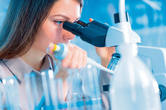 Scientist using a microscope in a laboratory.