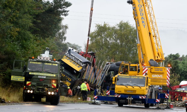 A crane in the process of removing the timber lorry