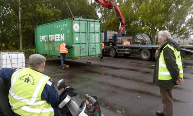 Dingwall Mens Shed members Raymond Jackson (left) and Steve Dovey watch as a container is unloaded.