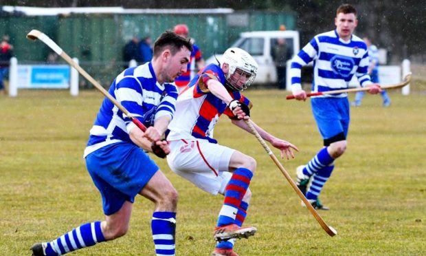 Shinty players jostle while in competition.