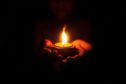 Little child holding burning candle in darkness with noise and grain effect.; Shutterstock ID 1158296245