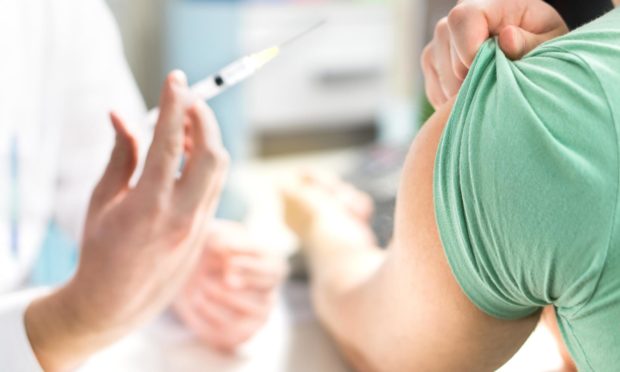 Doctor giving patient vaccine, flu or influenza shot or taking blood test with needle. Nurse with injection or syringe. Medicine, insulin or vaccination. Hospital office room.; Shutterstock ID 788107306