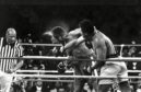 Perspiration flies from the head of George Foreman as he takes a right from challenger Muhammad Ali in the seventh round in the match dubbed Rumble in the Jungle in 1974.