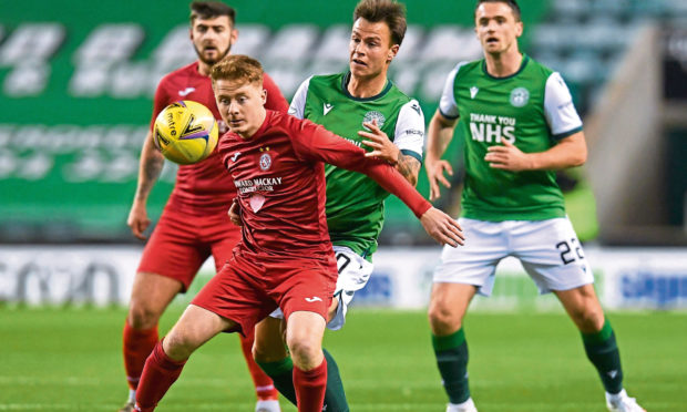 Brora's Andrew MacRae (L) holds off Hibernian's Melker Hallberg during a League Cup match at Easter Road last season.