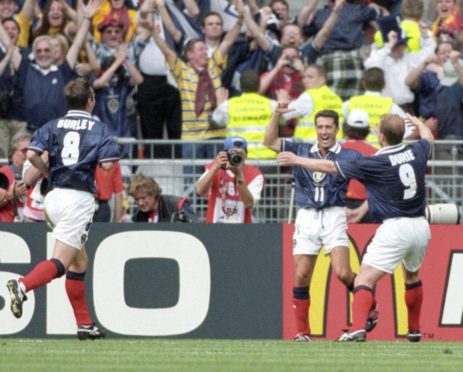 John Collins is hailed by Gordon Durie (right) and Craig Burley after equalising for Scotland from the penalty spot.