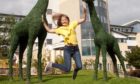 An Archie Foundation supporter jumps for joy outside Royal Aberdeen Children's Hospital.