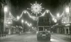 A number four bus drives along Union Street under the bright Christmas illuminations in 1964.