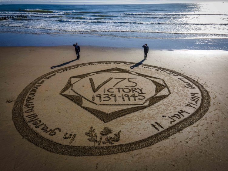 A 32-ft coin marking the 75th anniversary of Victory in Japan was created in the sand at Aberdeen beach.