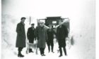 An image of men and a dog battling snow in Tomintoul has been included in the archive.