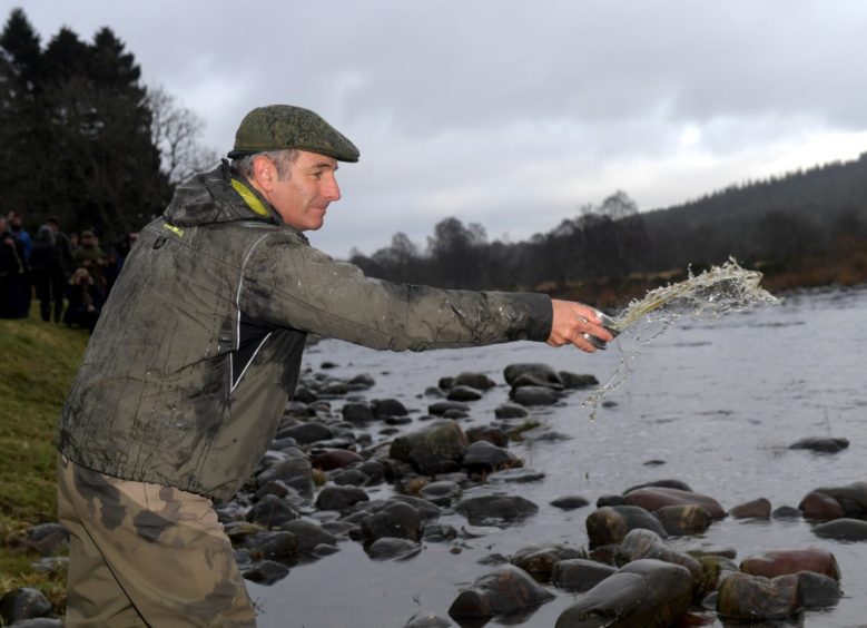 Robson Green splashes whisky into the Dee. 