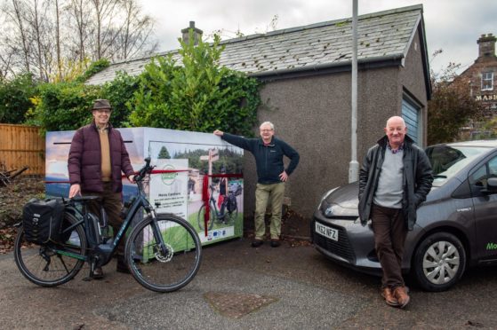 L-R: Gordon McAlpine, Manager Moray Carshare, resident William Malcolm and councillor Derek Ross unveil the new biking and car services in Aberlour.