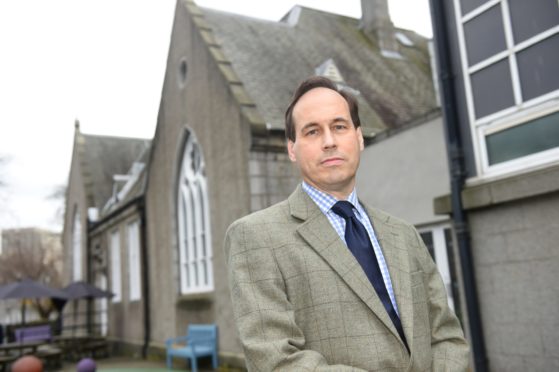 Martin Grieg standing outside former French School at corner of Esslemont Avenue and Whitehall Place.