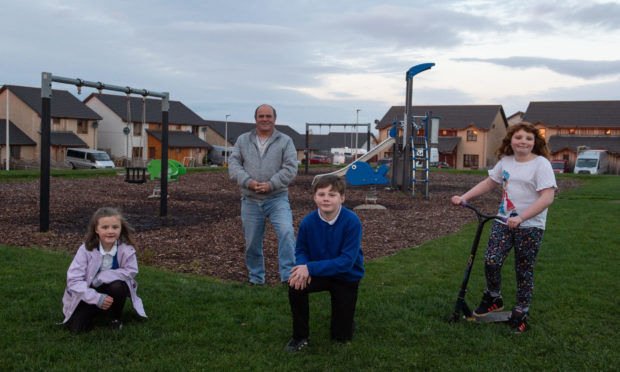 Buckie Riverside Church pastor John Coppard and the youngsters who have launched a petition urging Springfield to upgrade playpark in Seafield Estate in Buckpool by getting goalposts and a skate park.